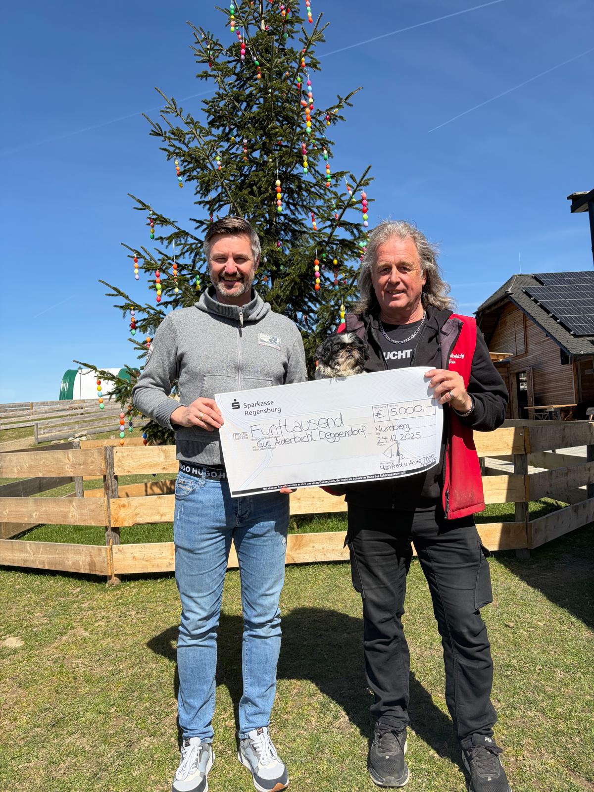 Alexander Grünert übergibt eine Spende an Gut Aiderbichl